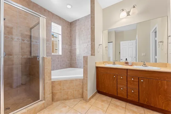 a spacious bathroom with a tub sink shower and mirror