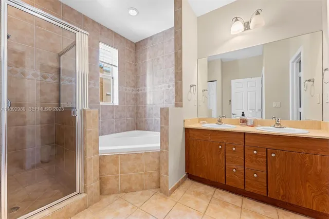 a spacious bathroom with a tub sink shower and mirror