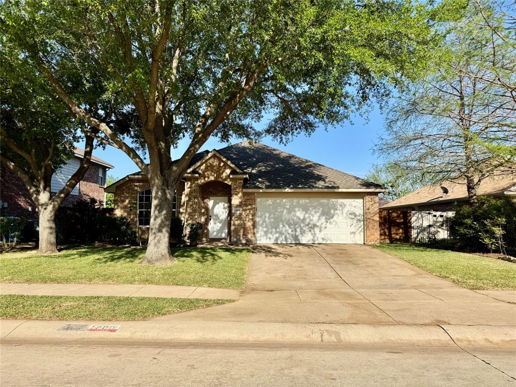 a view of a house with a yard and large trees