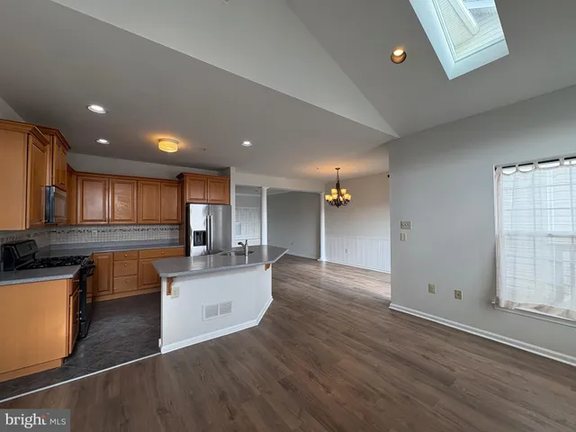 an open kitchen with kitchen island and stainless steel appliances