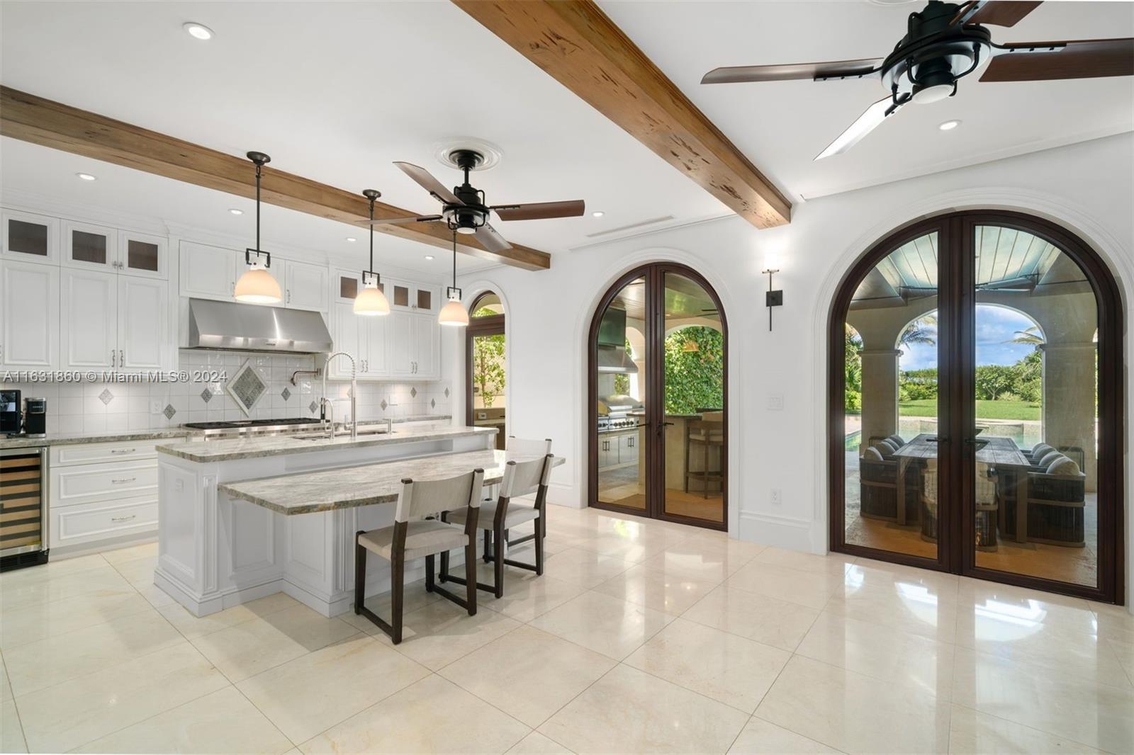 7825 Atlantic Way Miami Beach, FL 33141 - Photo 14 of 33 a kitchen with stainless steel appliances a stove a sink and a refrigerator