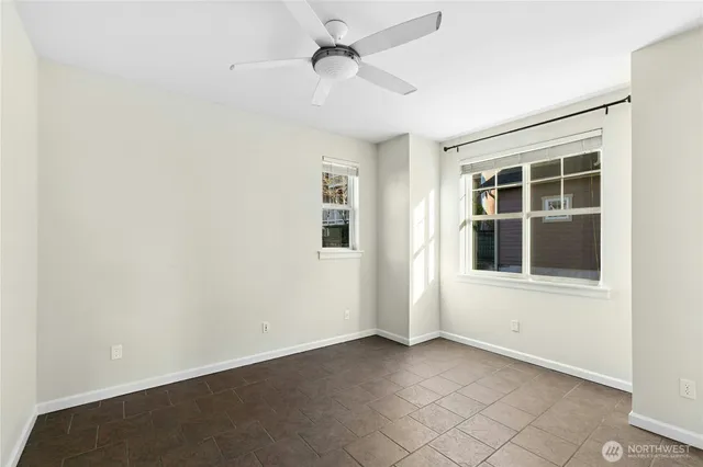 an empty room with windows and fan