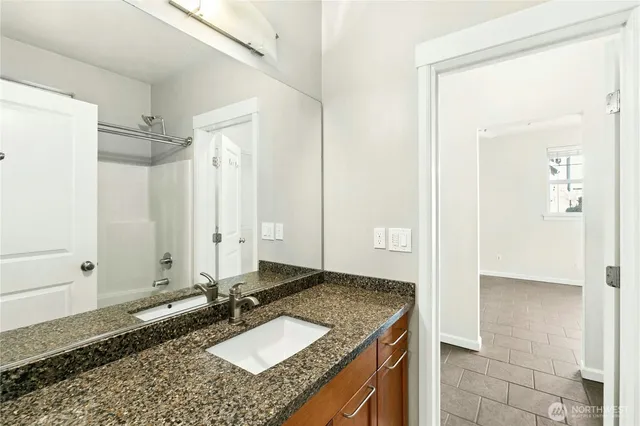 a bathroom with a granite countertop sink and a mirror