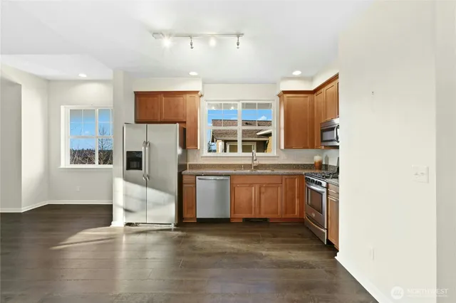 a kitchen with stainless steel appliances granite countertop a stove a sink and a refrigerator