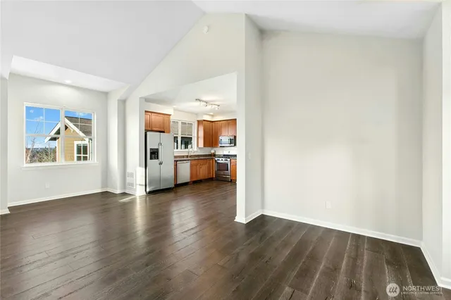 a view of a kitchen with wooden floor and electronic appliances