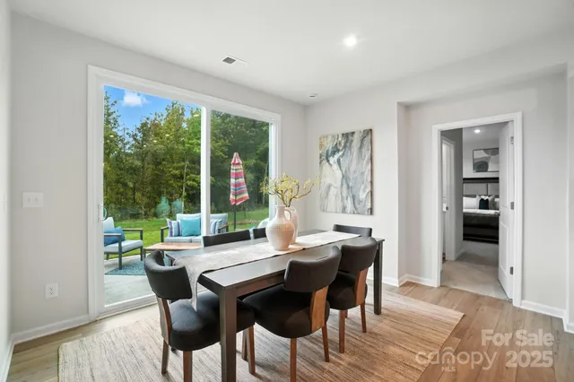 a dining room with kitchen island stainless steel appliances furniture a dining table and chairs
