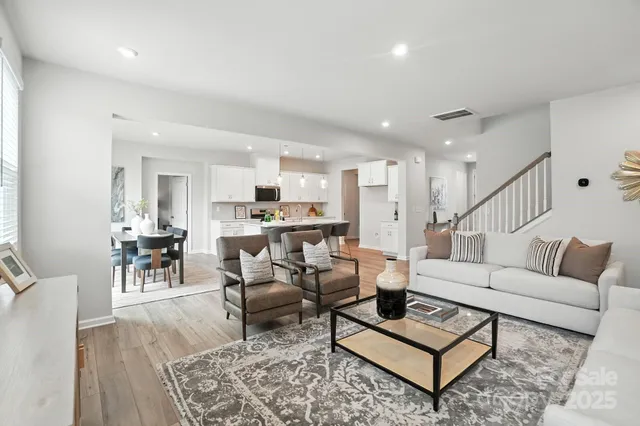 a living room with furniture and a dining table with wooden floor