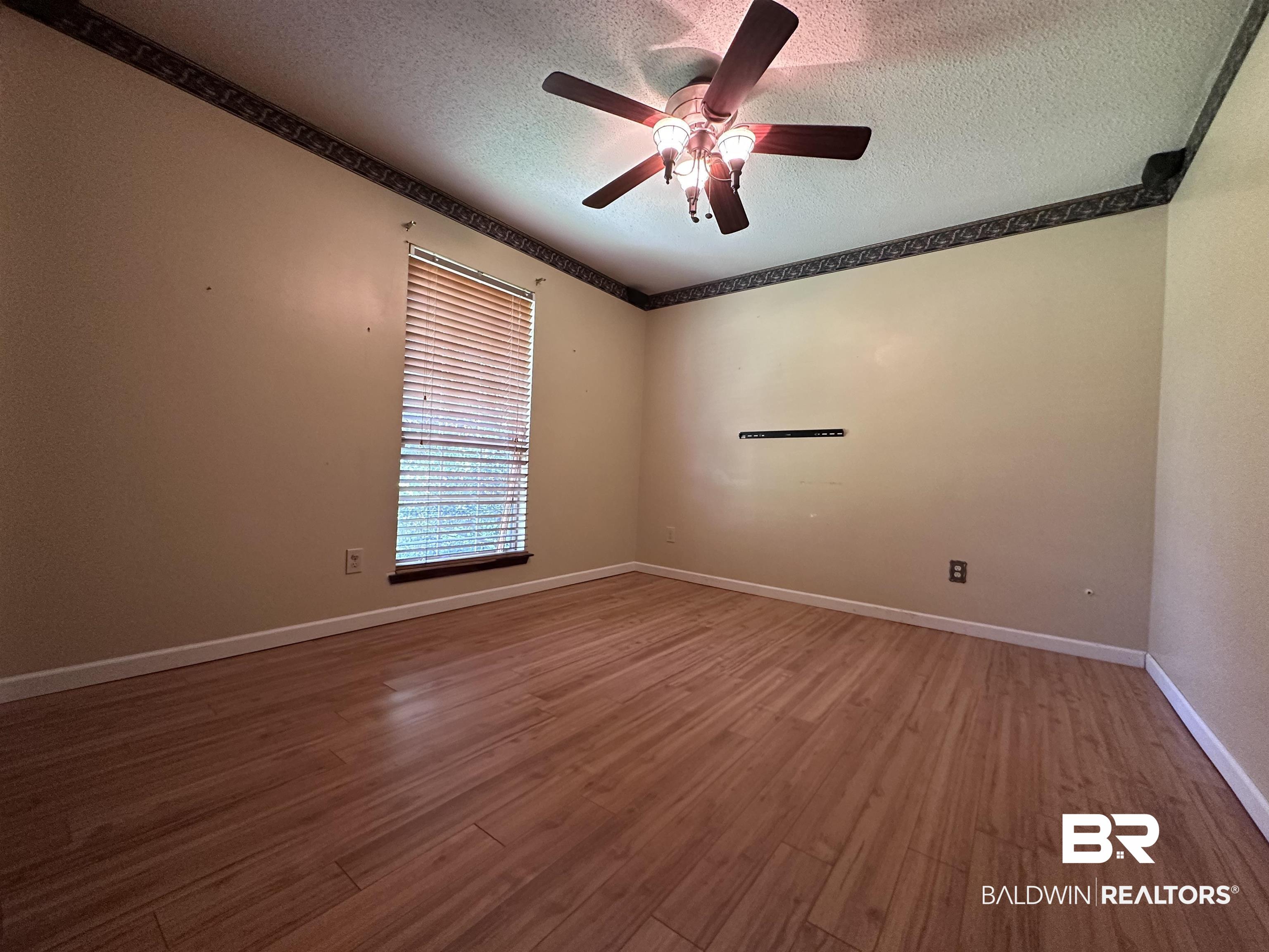 3613 Vista Ridge Drive Mobile, AL 36693 - Photo 7 of 9 Spare room with ceiling fan, hardwood / wood-style flooring, and a textured ceiling