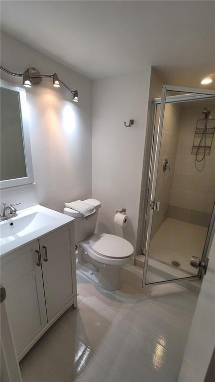 9273 Southwest 8th Street, Unit 109 Boca Raton, FL 33428 - Photo 3 of 22 a bathroom with a sink mirror vanity and toilet