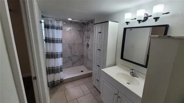 a bathroom with a shower sink and mirror