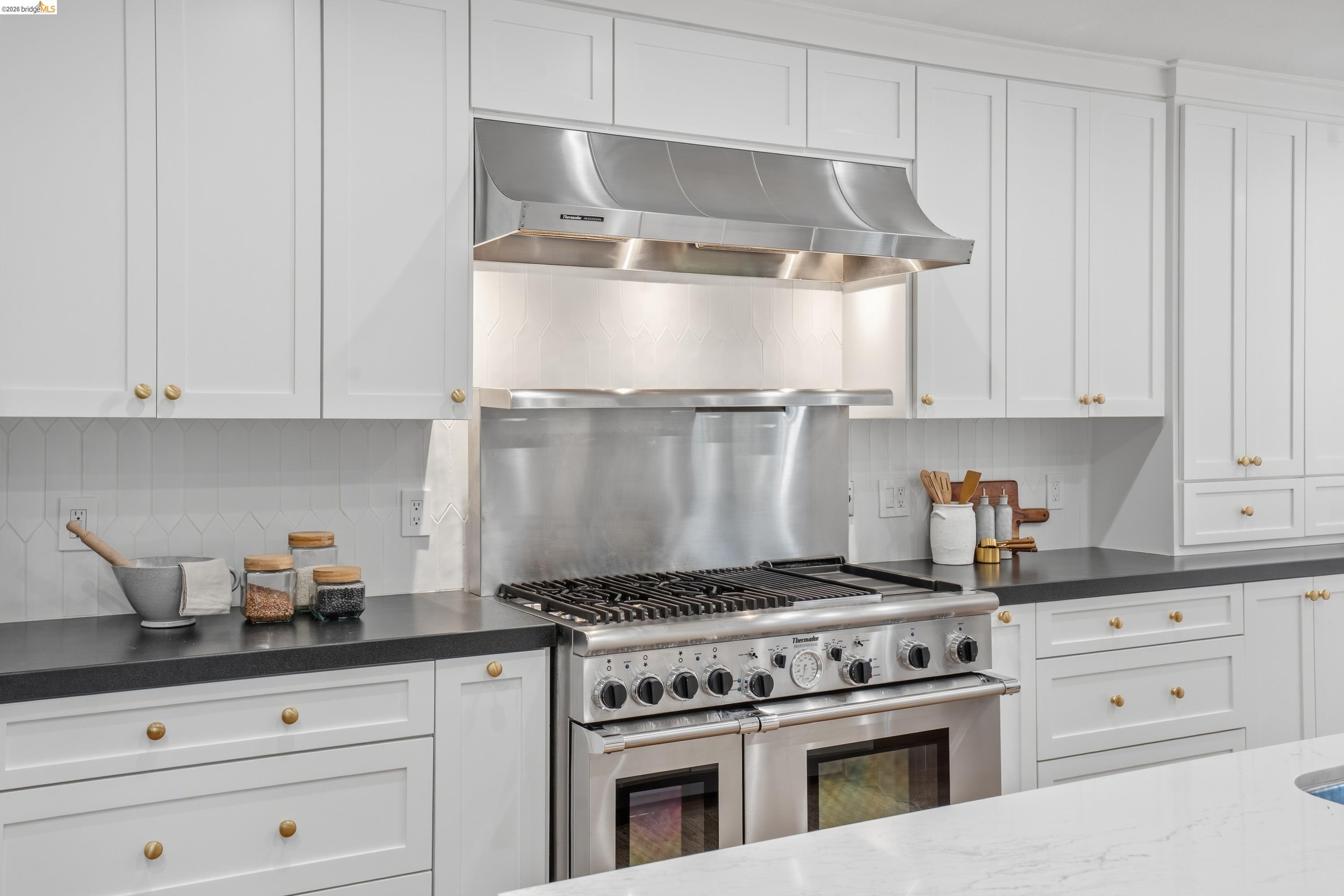 4120 Happy Valley Road Lafayette, CA 94549 - Photo 8 of 48 Professional-grade stainless steel range with a coordinating range hood, framed by white shaker-style cabinetry