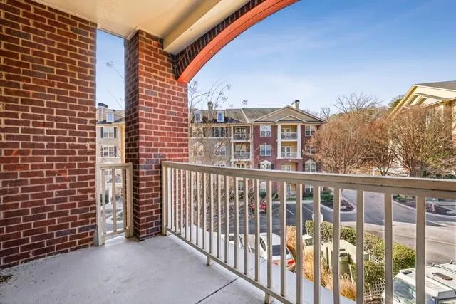 a view of a balcony with a couple of cars parked in parking lot