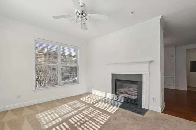 a view of an empty room with a fireplace and a window
