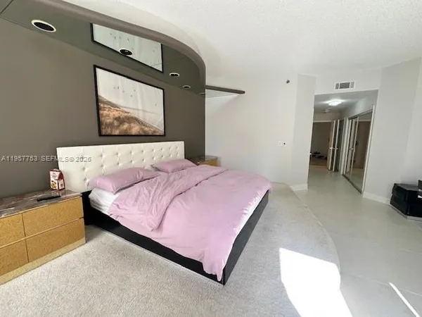 a bedroom with a bed and painting on the wall