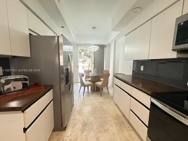 a kitchen with stainless steel appliances a sink a stove top oven a counter space and cabinets