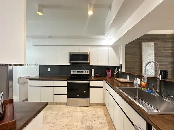 a large white kitchen with a stove and a refrigerator