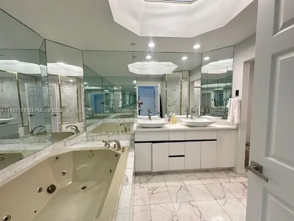 a bathroom with a tub a double vanity sink and mirror