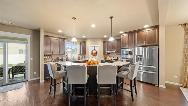a view of a dining room and livingroom with furniture wooden floor a chandelier