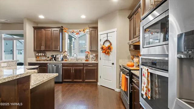 a kitchen with stainless steel appliances granite countertop a refrigerator and a stove top oven