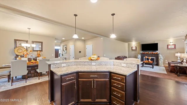 a view of a kitchen counter top space with furniture a fireplace and wooden floor
