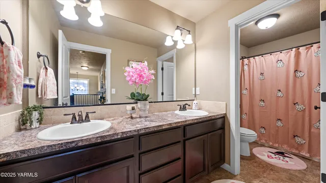 a bathroom with a granite countertop sink mirror and toilet