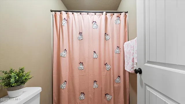 a bathroom with a shower curtain and a window