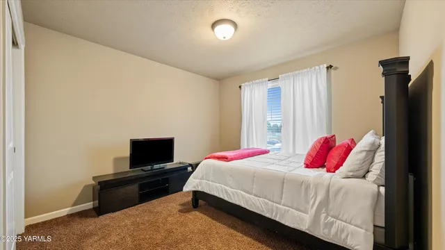 a bedroom with a bed and a tv