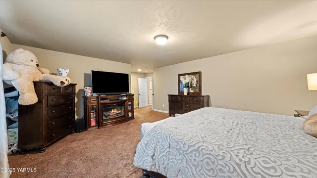 a large bedroom with a bed and a flat screen tv