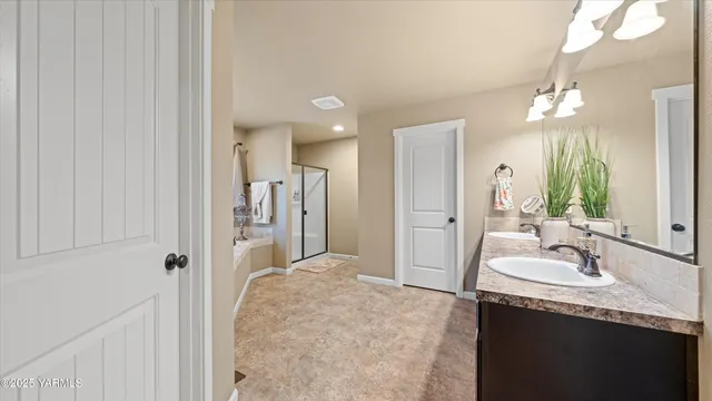 a bathroom with a granite countertop sink a mirror and a shower