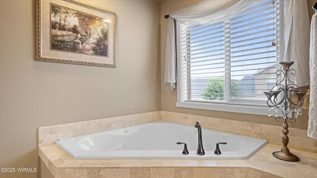 a white bath tub sitting in a bathroom next to a window