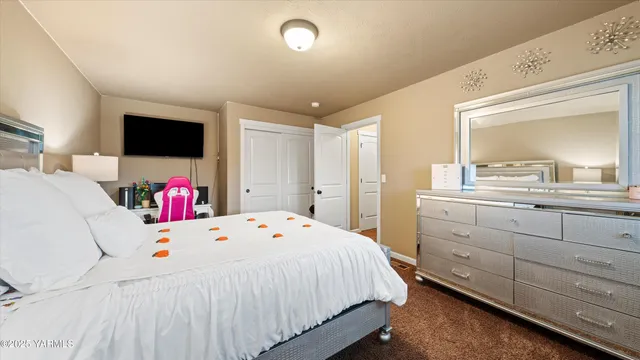 a bedroom with a bed a flat screen tv and a large window