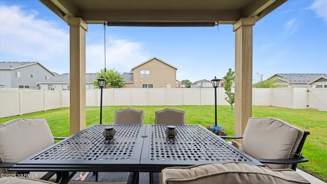 a view of a patio with table and chairs with wooden floor and fence