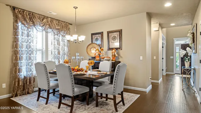 a dining room with furniture a chandelier and wooden floor