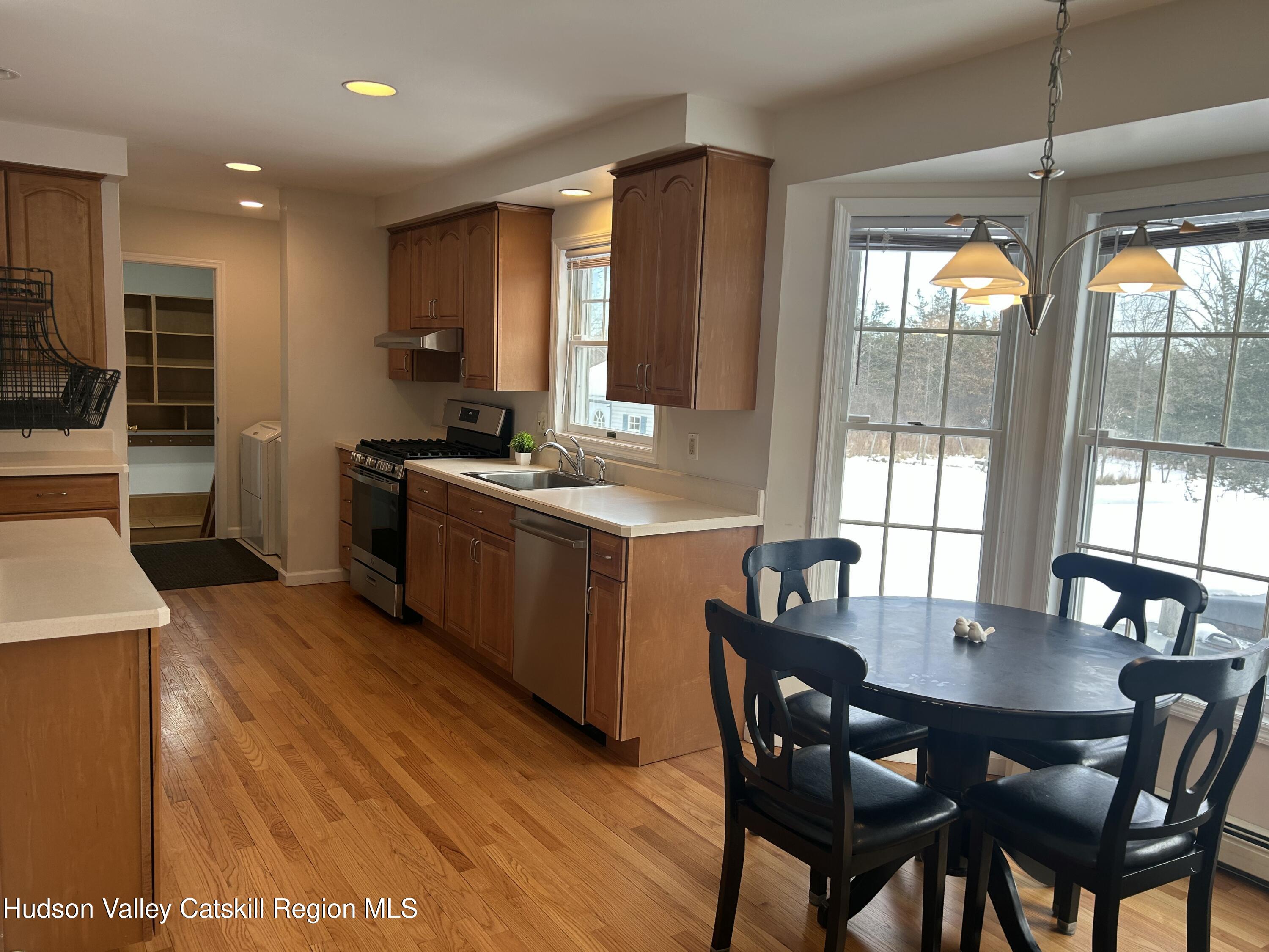 6 High Ridge Road New Paltz, NY 12561 - Photo 16 of 52 a kitchen with a stove a sink a dining table and chairs