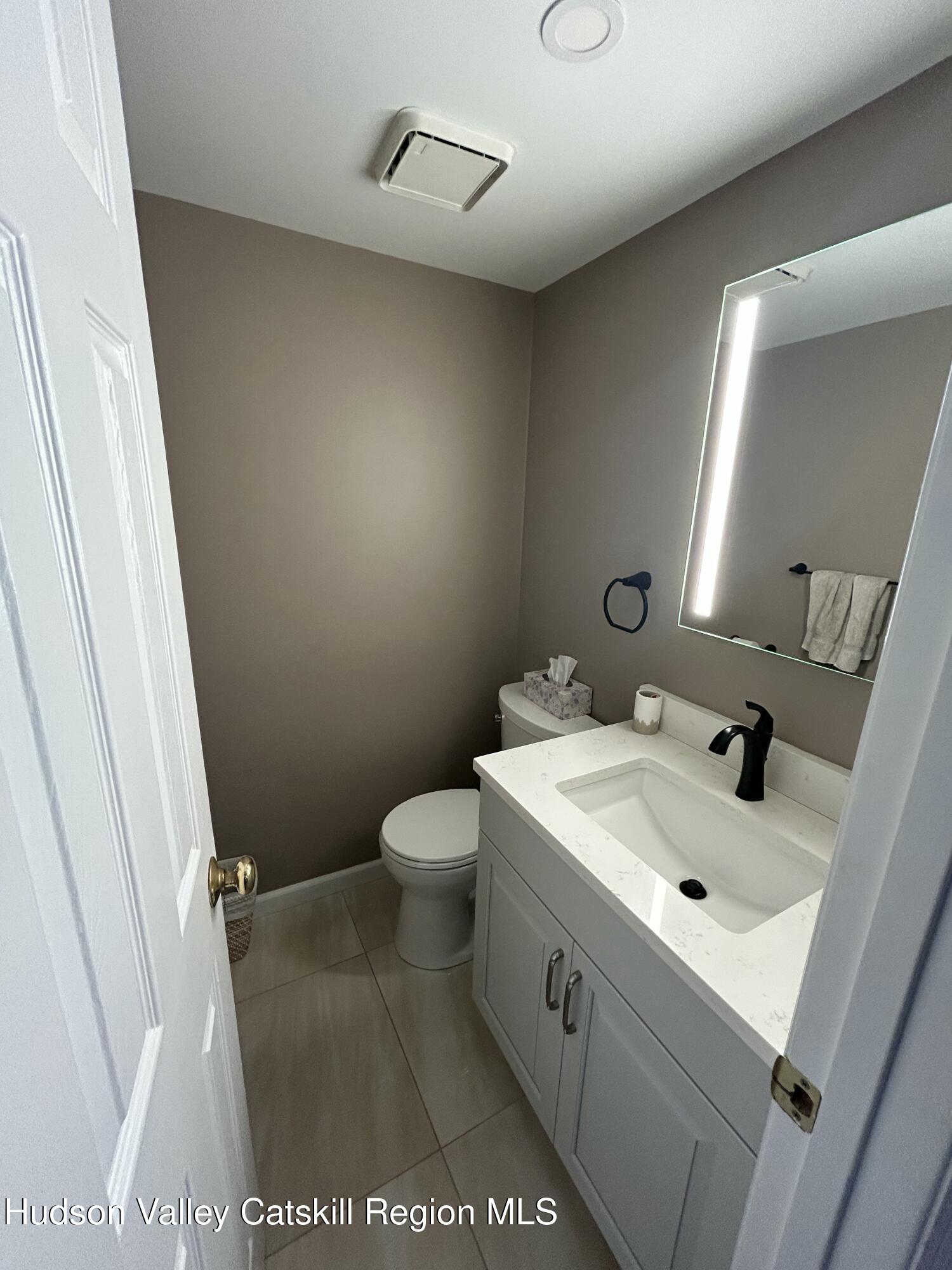 6 High Ridge Road New Paltz, NY 12561 - Photo 24 of 52 a bathroom with a sink a toilet and a mirror
