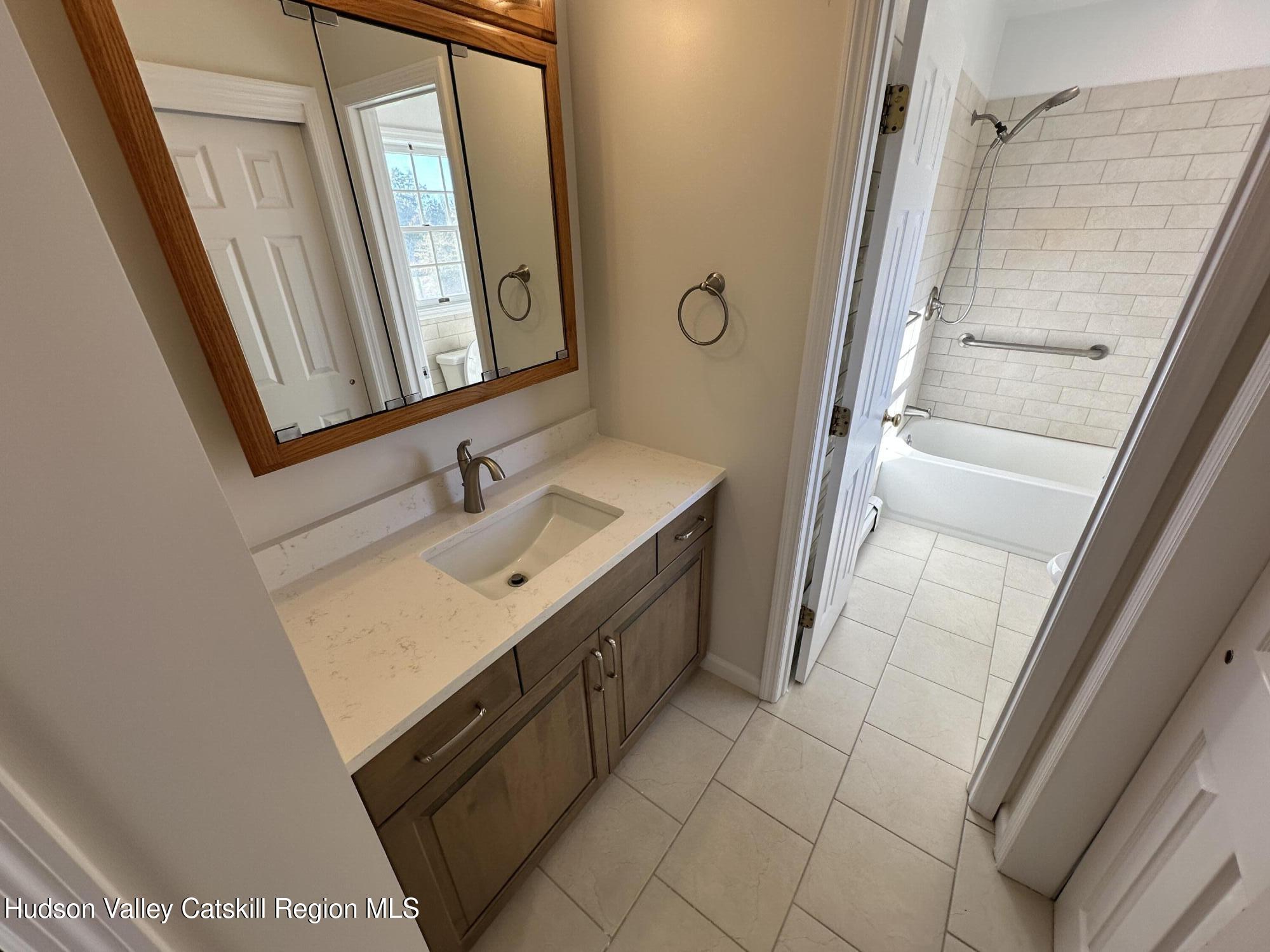 6 High Ridge Road New Paltz, NY 12561 - Photo 39 of 52 a bathroom with a sink a mirror and a shower