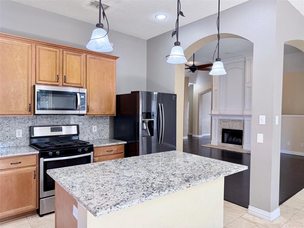 2607 Ridgeoak Trail Mansfield, TX 76063 - Photo 14 of 32 a kitchen with stainless steel appliances granite countertop granite counter tops refrigerator and a stove
