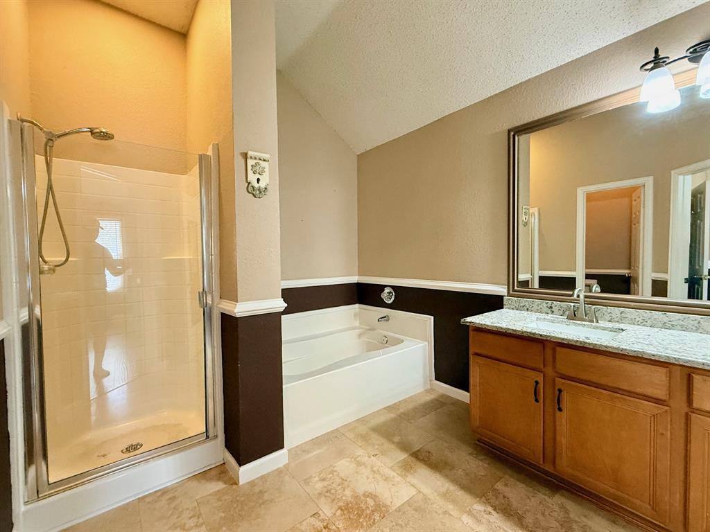 2607 Ridgeoak Trail Mansfield, TX 76063 - Photo 20 of 32 a bathroom with a granite countertop sink a mirror a bathtub and shower