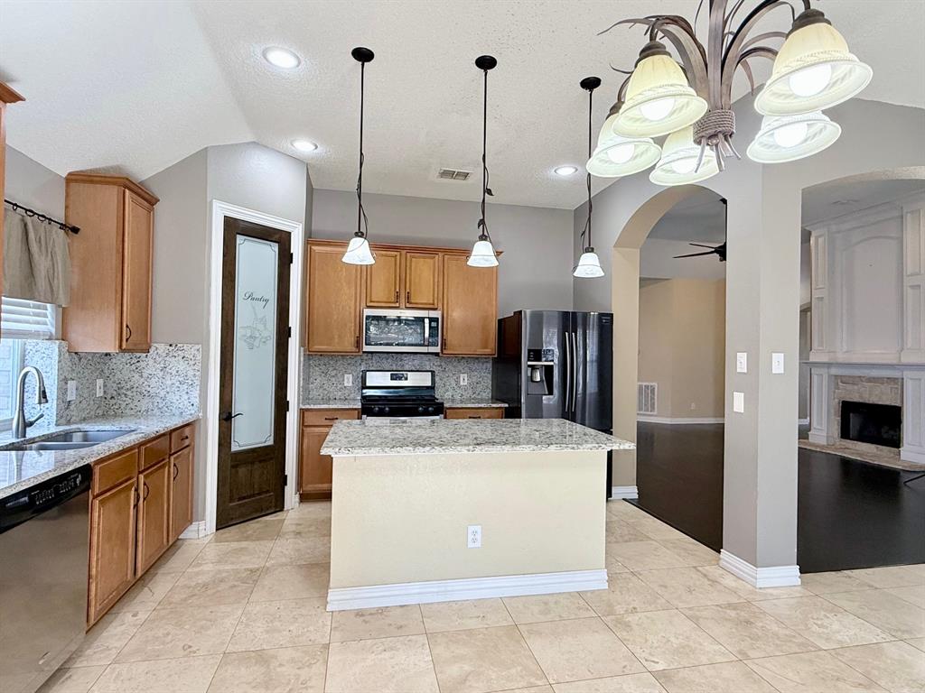 2607 Ridgeoak Trail Mansfield, TX 76063 - Photo 3 of 32 a large kitchen with kitchen island a large counter top stainless steel appliances and cabinets