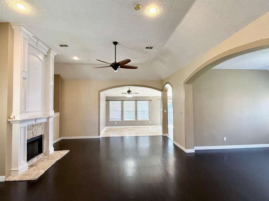 2607 Ridgeoak Trail Mansfield, TX 76063 - Photo 7 of 32 an empty room with a fireplace and wooden floor
