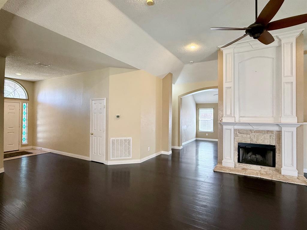 2607 Ridgeoak Trail Mansfield, TX 76063 - Photo 10 of 32 a view of an empty room with wooden floor and a fireplace