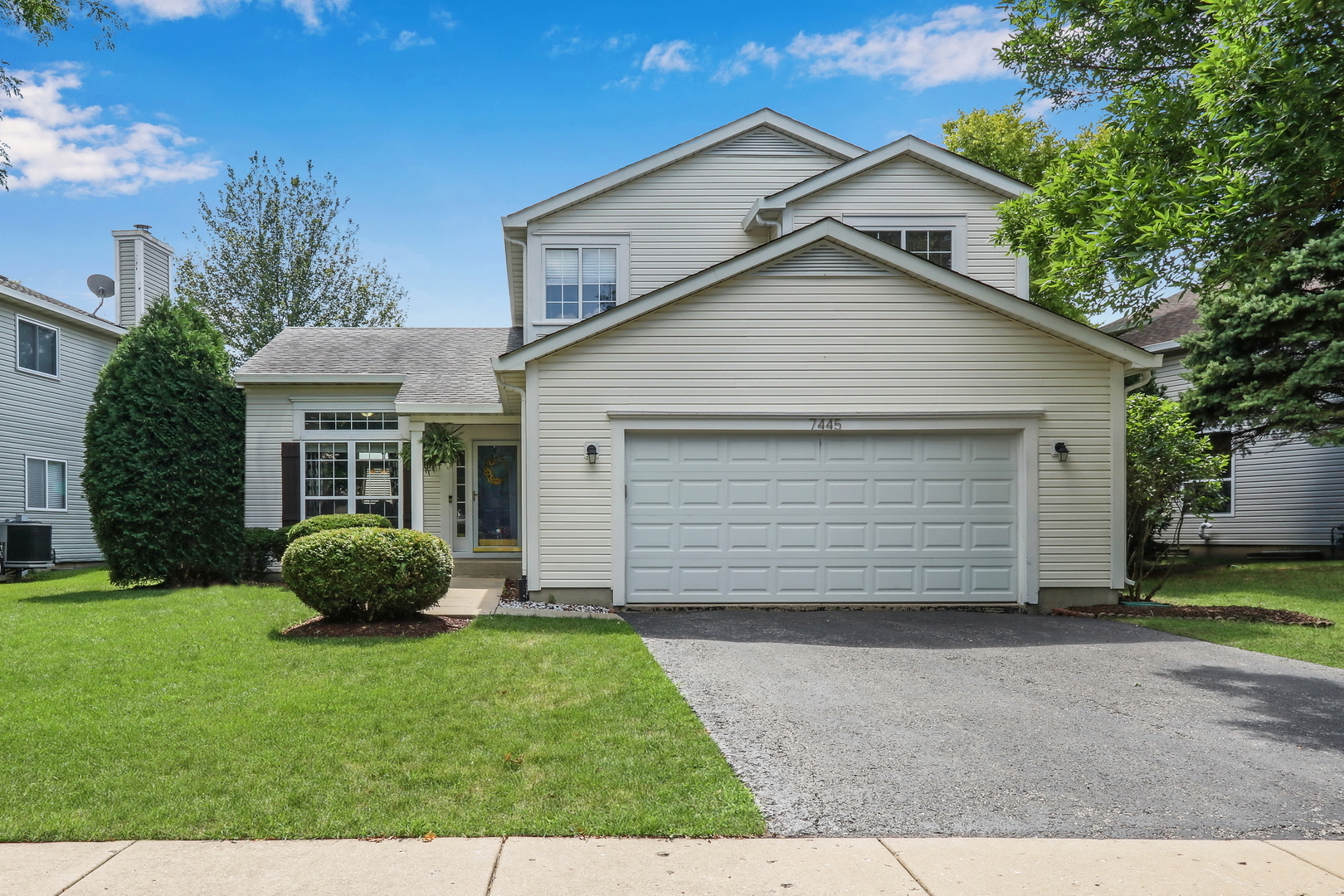 7445 Inglenook Lane Gurnee, IL 60031 - Photo 2 of 26 a front view of a house with a garden