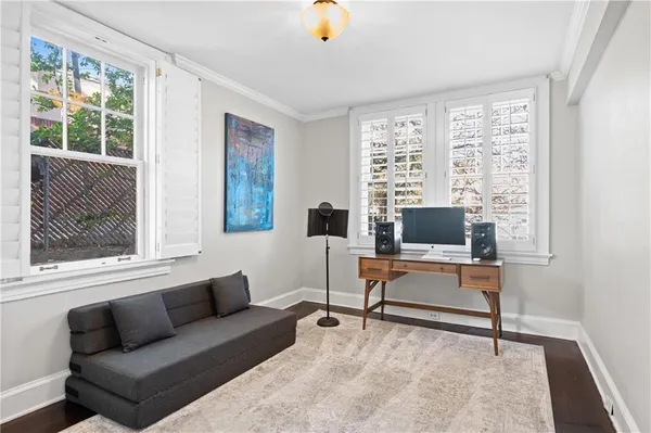 a living room with furniture a flat screen tv and a window