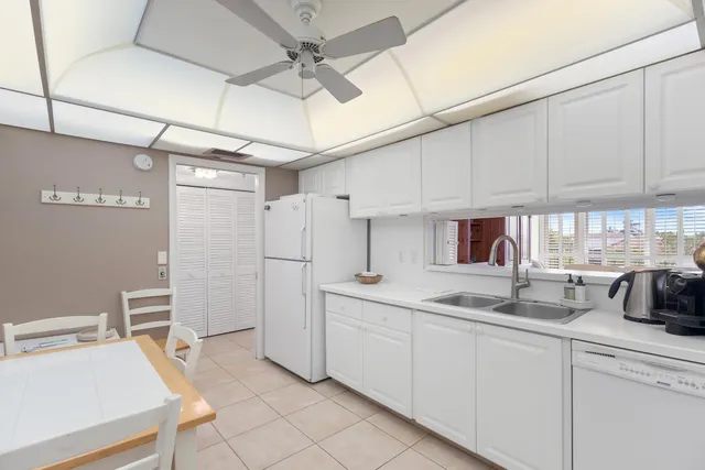 a kitchen with white cabinets and white appliances
