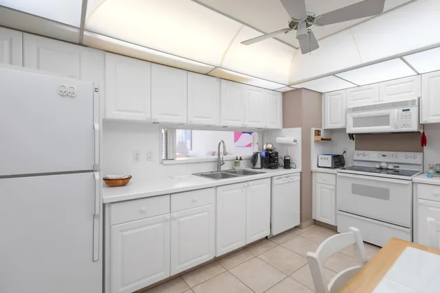 a kitchen with white cabinets and white appliances