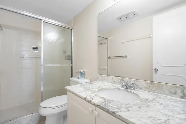 a bathroom with a granite countertop sink toilet and shower