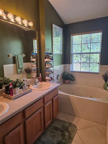 a spacious bathroom with a tub sink and mirror
