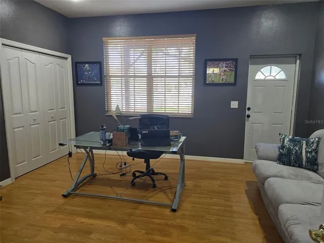 a view of a livingroom with workspace and a window