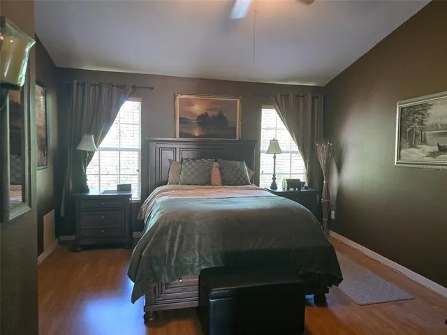 a bedroom with a bed window and wooden floor