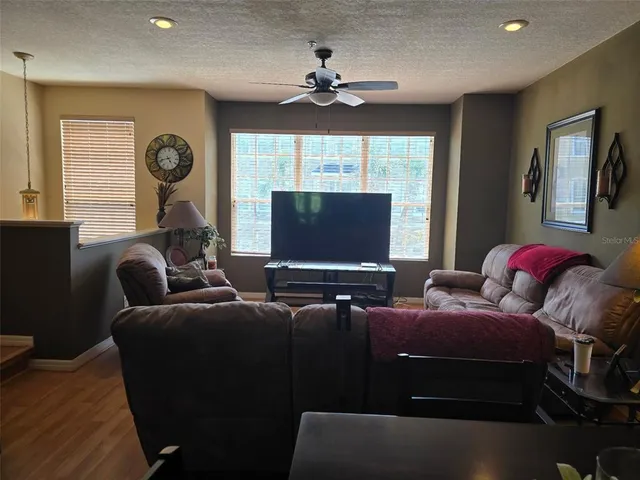 a living room with furniture a large window and flat screen tv